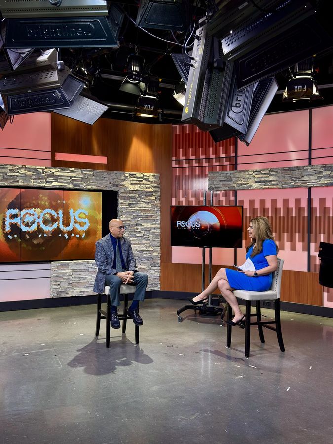 A client being interviewed on a television news set